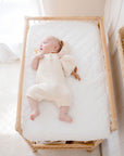 Baby lying on Ivory Waterproof Co Sleeper Bassinet Sheet on Changing Table