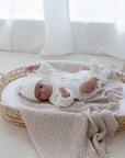 Newborn baby in bassinet lying on Haze cotton knit blanket