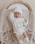 Baby in bassinet lying on Haze cotton knit blanket