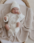 Newborn baby lying on Haze cotton knit blanket